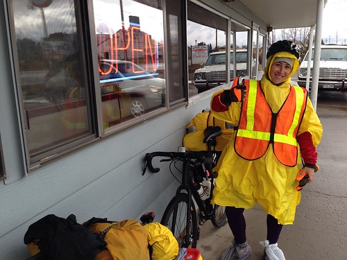 Megan in her rain gear in front of Deb's Diner in Dove Creek